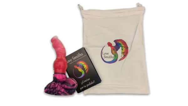 Product display showing a pink fantasy silicone toy with a dark marbled base, a Love Smiths thank-you card, and a cream drawstring storage bag featuring the Love Smiths logo.