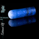 Masturbador Tattooed Elf Epic en silicona azul iridiscente y blanca, con ornamentados patrones de tatuajes élficos y acabado reflectante.