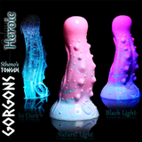 Gorgon’s Stheno’s Tongue dildo glowing blue in dark, pink in natural light, and purple under blacklight.