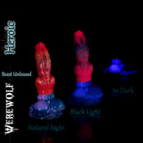 Fantasy silicone werewolf dildo in the Heroic colourway, shown in three lighting conditions: red and metallic tones in natural light, vivid neon glow under black light, and an intense blue glow effect in complete darkness.